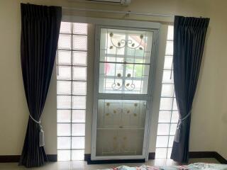 Bedroom window with curtains and security grill