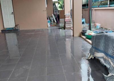 Covered outdoor patio area with dark tiles