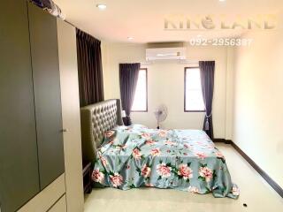 Spacious bedroom with large windows and floral bedspread