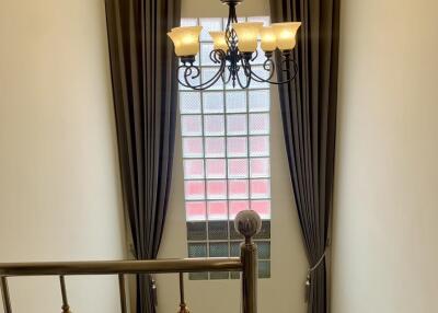 Elegant staircase with chandelier and large window