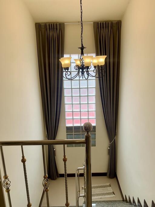 Elegant staircase with chandelier and large window