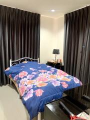 Cozy bedroom with floral bedding and dark curtains