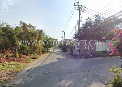 Street view of neighborhood with greenery and power lines