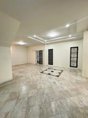 Spacious living room with tiled flooring and ceiling lights