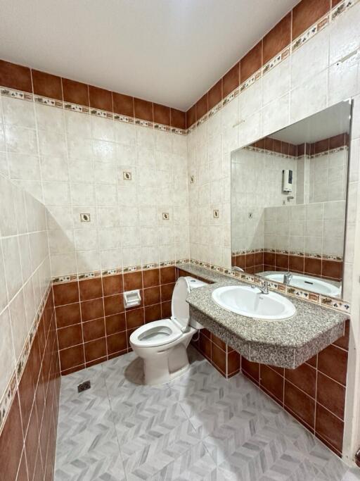 Bathroom with tiled walls and a large mirror