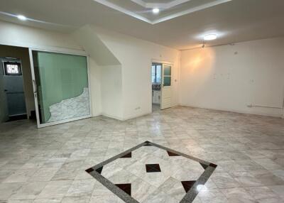 Spacious living room with tiled flooring and ceiling lights