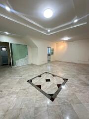 Spacious living room with tiled flooring and ceiling lights