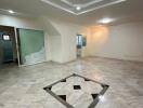 Spacious living room with tiled flooring and ceiling lights