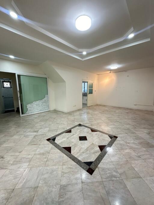 Spacious living room with tiled flooring and ceiling lights