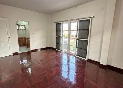 Spacious bedroom with polished wooden floor and large windows