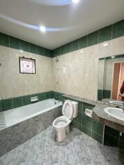 Bathroom with bathtub, toilet, sink, and tiles