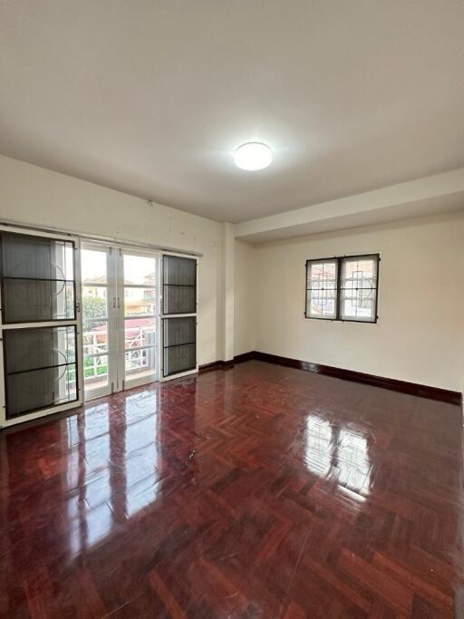 Spacious living room with large windows and polished wooden floor