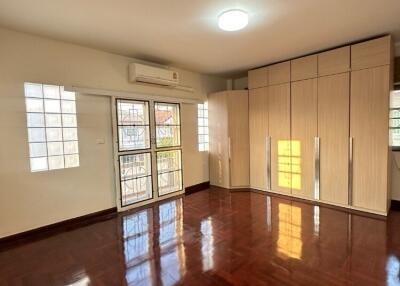 Spacious bedroom with wooden floor and large windows