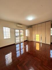 Spacious bedroom with wooden floor and large windows