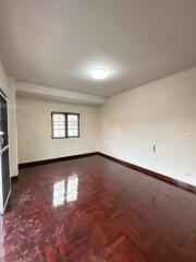 Empty bedroom with wooden floor and window