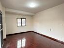 Empty bedroom with wooden floor and window