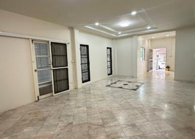 Spacious living room with tiled floor and large windows.