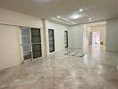 Spacious living room with tiled floor and large windows.