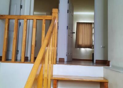 Interior staircase leading up to a hallway with doors and rooms