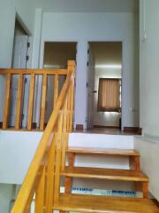 Interior staircase leading up to a hallway with doors and rooms