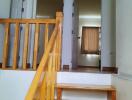 Interior staircase leading up to a hallway with doors and rooms