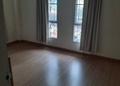 Empty bedroom with two windows and curtains