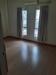 Empty bedroom with two windows and curtains