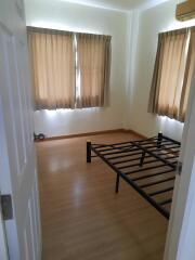 Empty bedroom with window curtains and bed frame