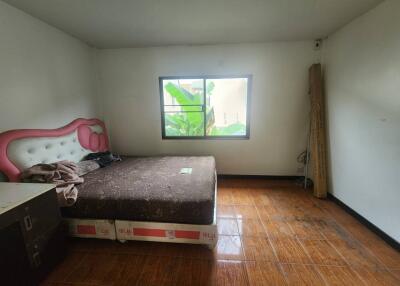 Spacious bedroom with window and wooden flooring