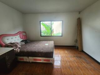 Spacious bedroom with window and wooden flooring