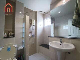 Modern bathroom with toilet, sink, and shower