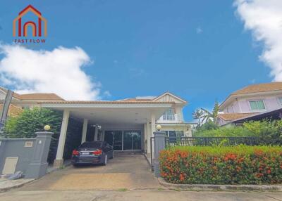 Exterior view of a residential house with carport and garden