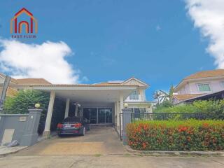 Exterior view of a residential house with carport and garden