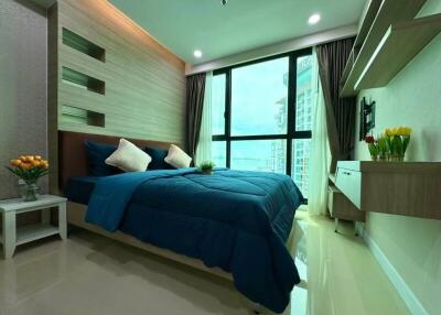 Modern bedroom with large window and blue bedding