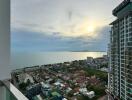 Balcony view overlooking cityscape and ocean at sunset