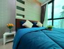 Modern bedroom with blue bedding and large window