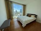 Bright bedroom with a large window offering a city view