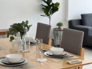 Modern dining area with table setting and houseplants