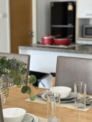 Dining table with bowls and glasses, kitchen in the background