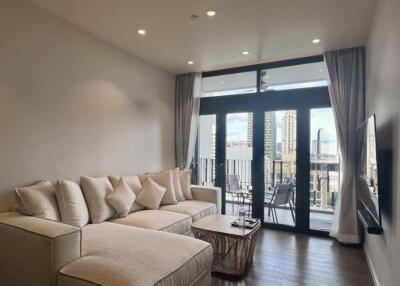 Modern living room with a large beige sectional sofa and balcony access