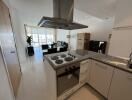 Modern kitchen with granite countertops and open living area in background