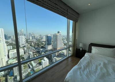 High-rise bedroom with large window offering city view