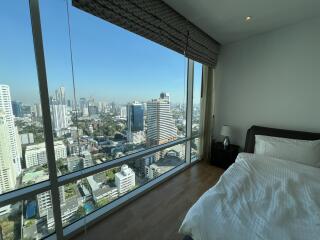 High-rise bedroom with large window offering city view