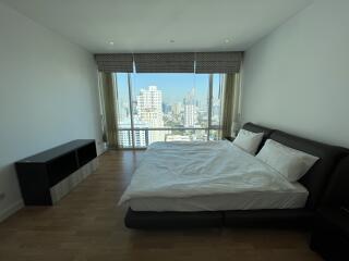 Spacious modern bedroom with large window and city view