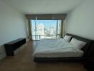 Spacious modern bedroom with large window and city view