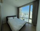 Modern bedroom with large windows and city view