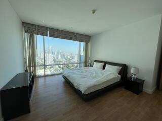 Spacious bedroom with a large window and city view