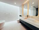 Modern bathroom with double sink vanity, freestanding bathtub, and large mirror