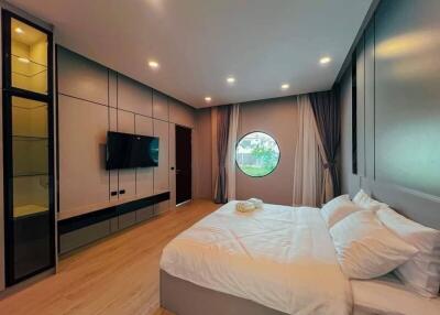 Modern spacious bedroom with large bed and circular window