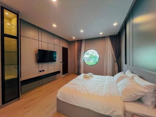 Modern spacious bedroom with large bed and circular window